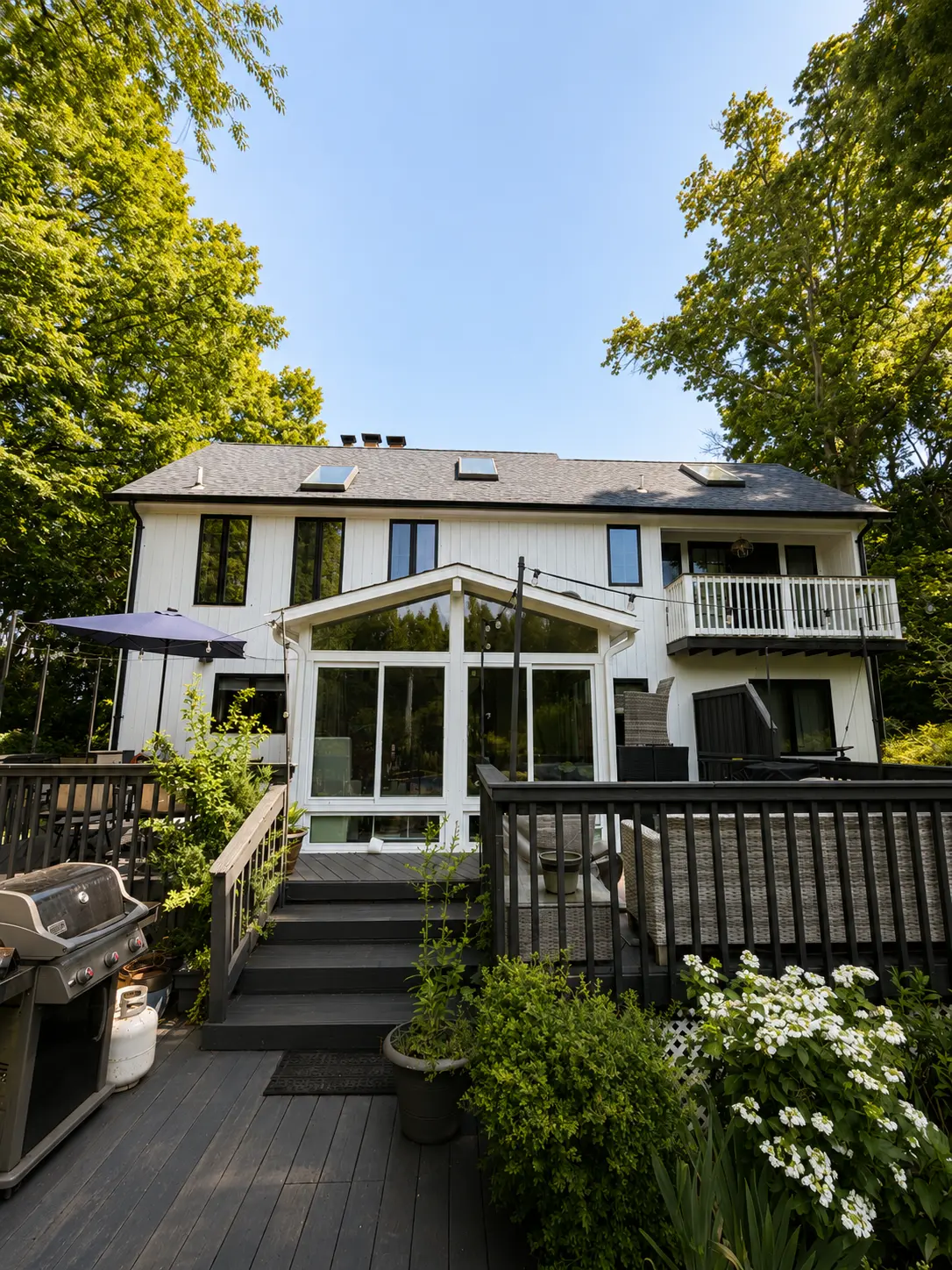 Nassau County cape or split-level home with a completed exterior repaint — fresh siding color, sharp white trim, repainted shutters and front door.