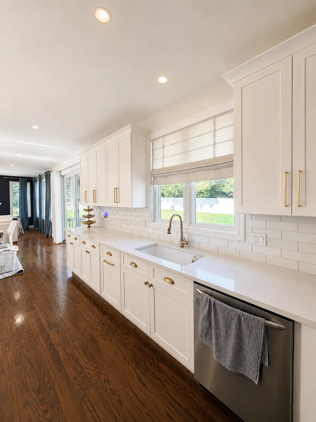 Newly painted kitchen with refinished white shaker cabinets, warm grey walls and clean caulk lines where the cabinets meet the wall.