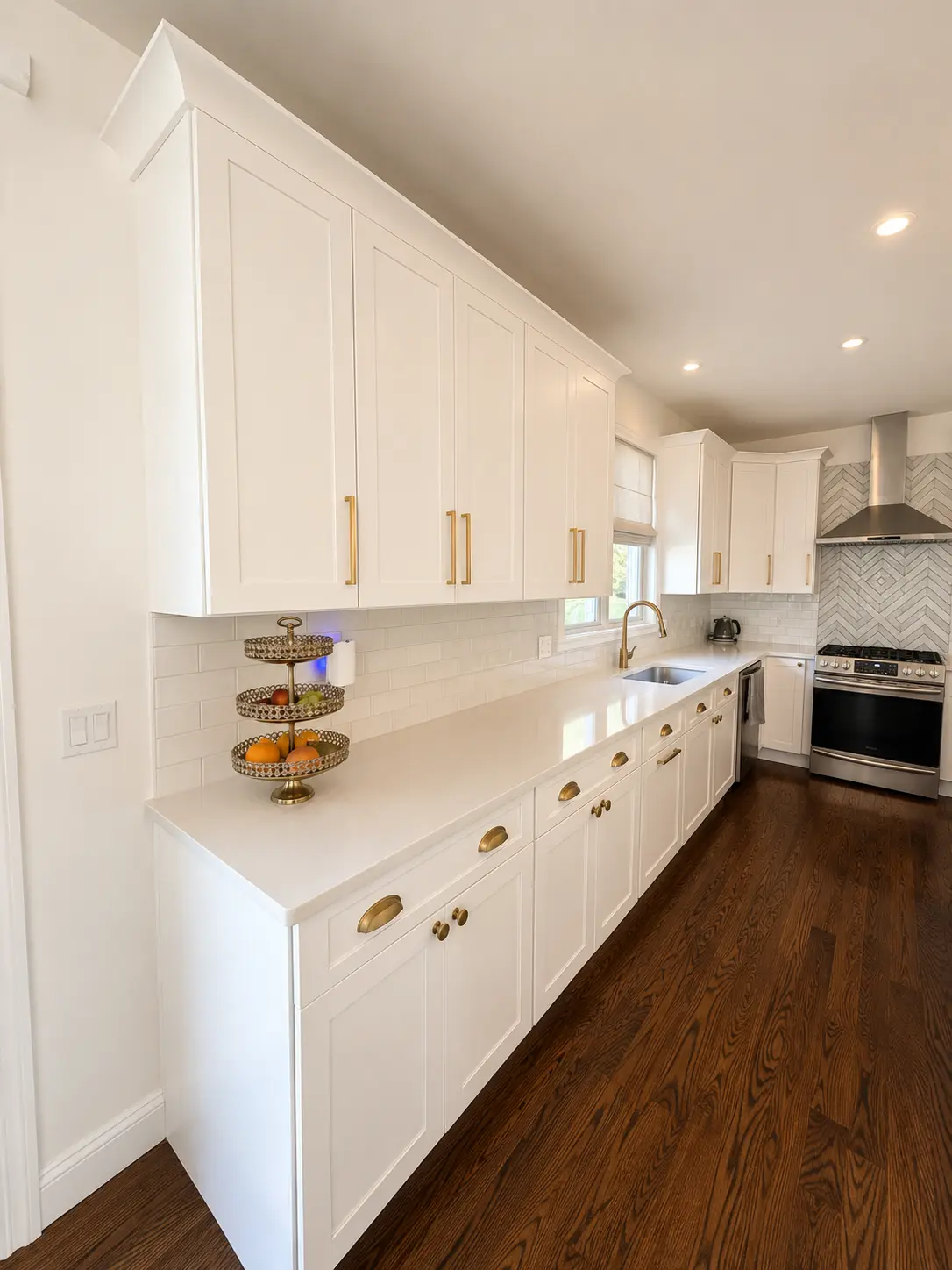 Kitchen cabinets refinished from dark oak to a smooth white, with new hardware and a clean caulk line at the wall.